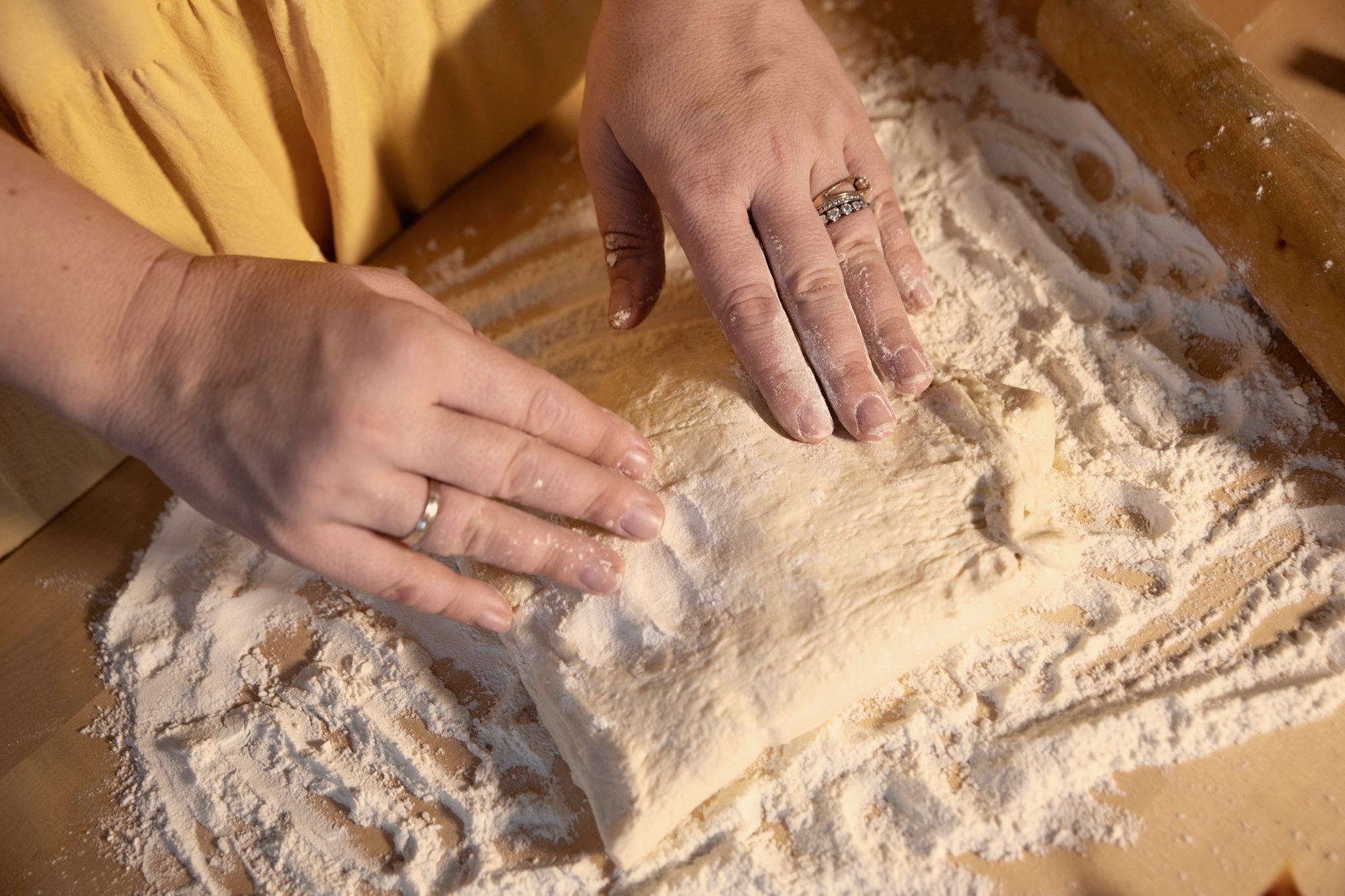 Hands pressing a floured round of dough, minute zero